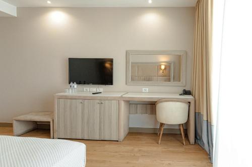 a bedroom with a desk with a television and a chair at Royal G Hotel & SPA 4 Star in Durrës
