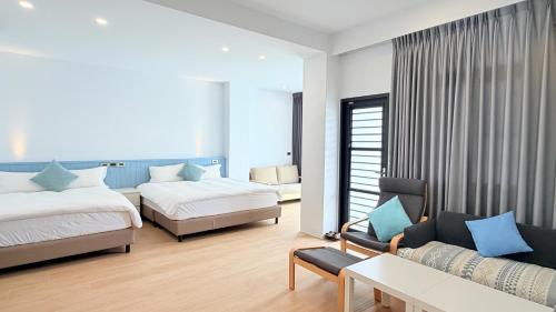 a hotel room with two beds and a couch at 台東靜巷19號民宿編號1901 in Taitung City