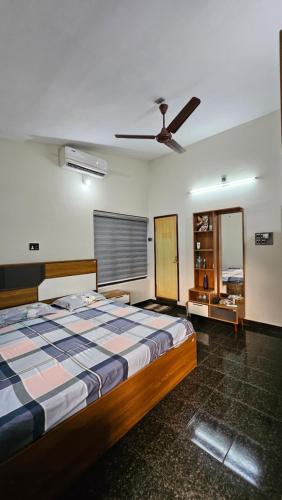 a bedroom with a bed and a ceiling fan at Marwa in Kannur