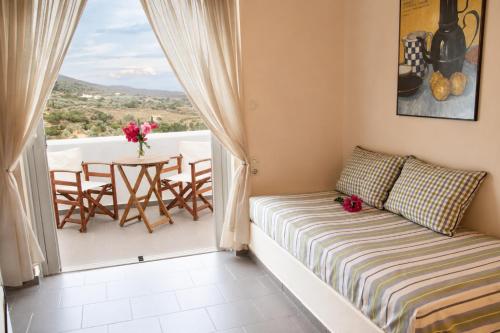a room with a couch and a table on a balcony at 9 Muses in Andros