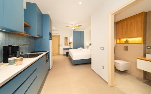 a kitchen with blue cabinets and a bed in a room at Georgina in Agia Marina Nea Kydonias