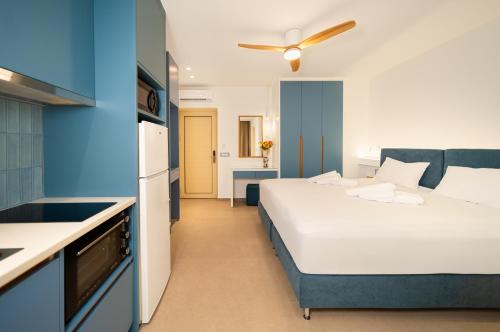 a bedroom with a white bed and a blue wall at Georgina in Agia Marina Nea Kydonias