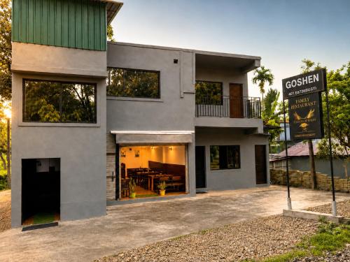 a gray house with a sign in front of it at Goshen dormitory in Siliguri