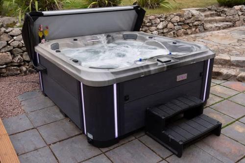 a hot tub sitting on a patio at Woodside Barn in Newmacher
