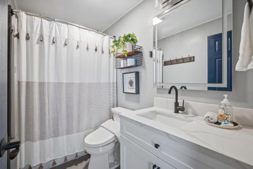 a white bathroom with a sink and a toilet at Laguna oasis Pool, Jacuzzi, Sauna in Laguna Hills