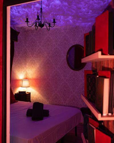 a purple room with a bed and a lamp at La Suite Magique du Sorcier in Nîmes