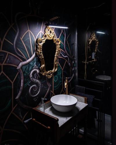 a bathroom with a sink and a mirror on a wall at La Suite Magique du Sorcier in Nîmes