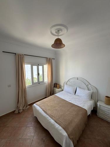 a bedroom with a large bed and a window at Appartement à Miramar in Martil