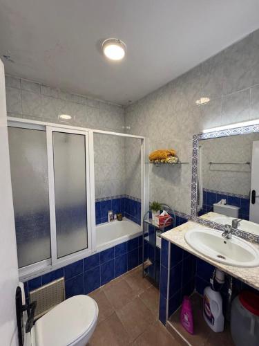a bathroom with a toilet and a sink and a tub at Appartement à Miramar in Martil