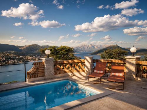 a swimming pool on a patio with a view of the mountains at Casa Verde 27 in Herceg-Novi
