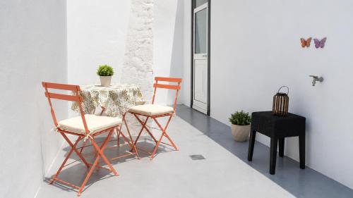 a table and two chairs in a room with a table and a stool at Faial Inn in Horta