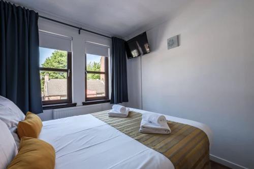a bedroom with a bed with two towels on it at The Douglas - Spacious 2 bed apartment in Uddingston in Uddingston