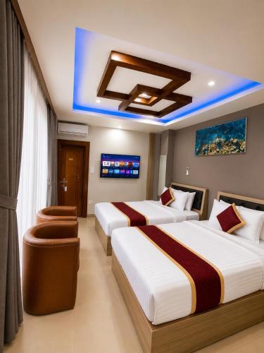 a hotel room with two beds and a tv at Chris Bed and Breakfast by Hostmandu in Jawlakhel