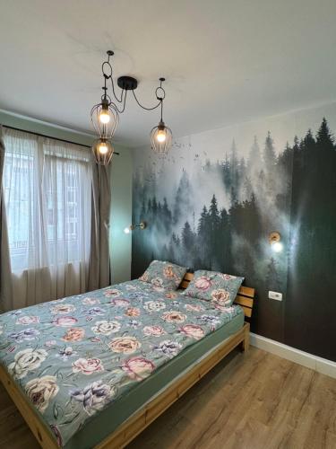 a bedroom with a bed with a painting on the wall at Apartament Tudor in Făgăraş