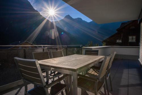 a table and chairs on a balcony with a view of a mountain at Appart Gastauer in Sankt Gallenkirch