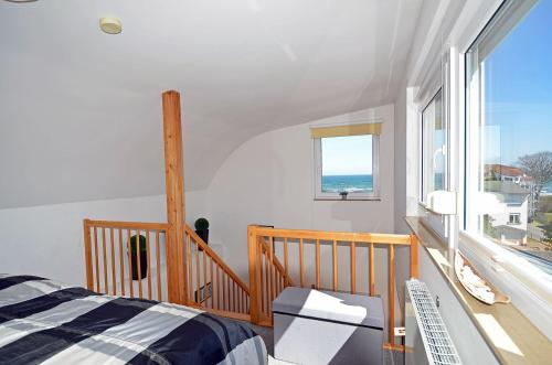 a bedroom with a bed and a view of the ocean at Bella Casa 42 - SternenMeer in Juliusruh