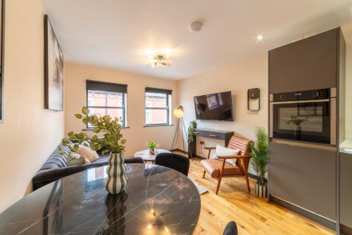 a living room with a couch and a table at LS1 - Luxury City Centre Apartments Leeds in Leeds