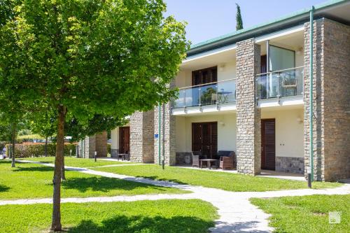a brick building with a tree in front of it at Chianti Village - Free Parking & Pool in Tavarnelle Val di Pesa
