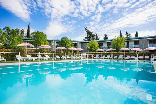 a swimming pool with chairs and umbrellas at Chianti Village - Free Parking & Pool in Tavarnelle Val di Pesa