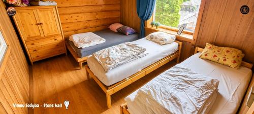 a small room with two beds and a window at Vilimu Sodyba - Stone Hall in Kriukai