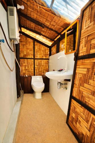 a bathroom with a toilet and a sink at Flower Power Farm Village in Ko Phayam