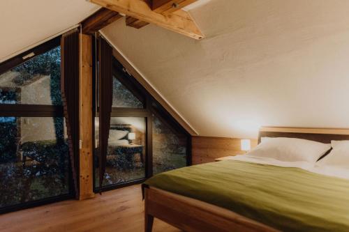 a bedroom with a bed and large windows at Chalet im Obstgarten in Lengau