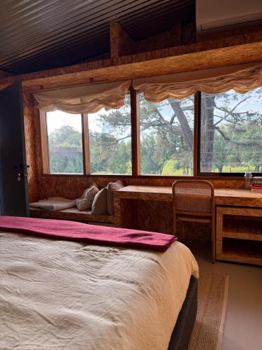 a bedroom with a large bed and a window at The Grasshouse Cabins in Burrawang