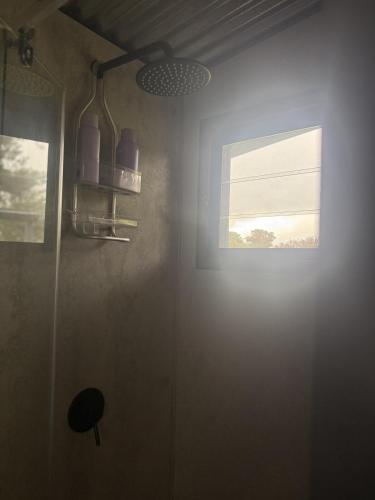 a room with a window with a light on the wall at The Grasshouse Cabins in Burrawang
