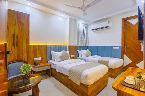 a hotel room with two beds and a table at Hotel Shivkashi Palace By G K Group in Varanasi