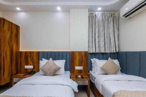 two beds in a room with blue and white at Hotel Shivkashi Palace By G K Group in Varanasi