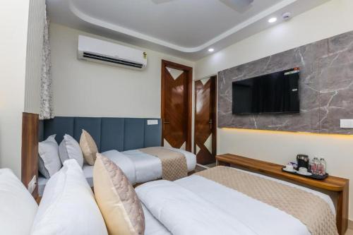 a hotel room with two beds and a flat screen tv at Hotel Shivkashi Palace By G K Group in Varanasi
