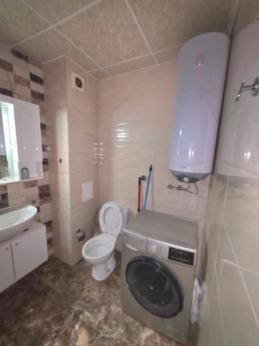 a bathroom with a washing machine and a toilet at Mountain View Apartment in Sofia
