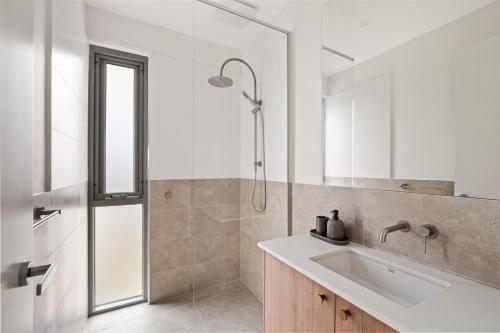 a white bathroom with a sink and a shower at The Cape Collective 6 in Margaret River Town