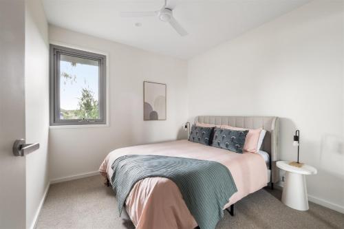 a white bedroom with a bed and a window at The Cape Collective 6 in Margaret River Town