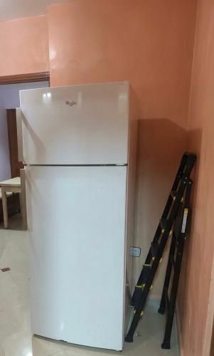 a white refrigerator in a room with a wall at مراكش تامنصورت in Aït Ali