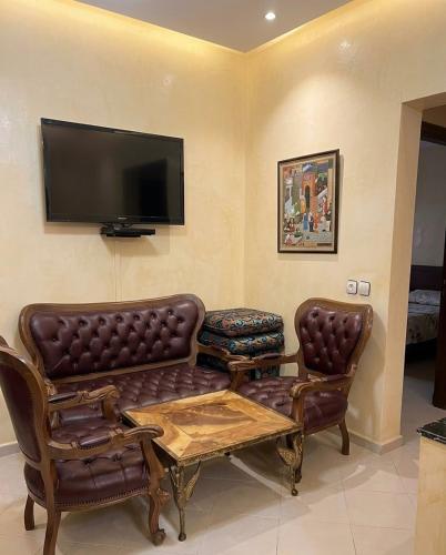 a living room with a couch and a tv at مراكش تامنصورت in Aït Ali