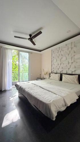 a bedroom with a large bed with a ceiling fan at Hotel Simba by Hakuna in Arambol