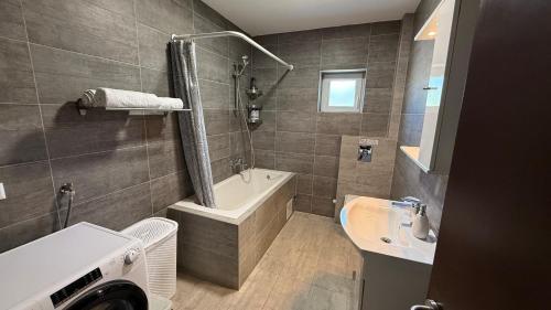 a bathroom with a tub and a sink and a bath tub at Private Villa Bonaventura with Pool & Jacuzzi & BBQ for Families & Groups near Split in Donja Mala