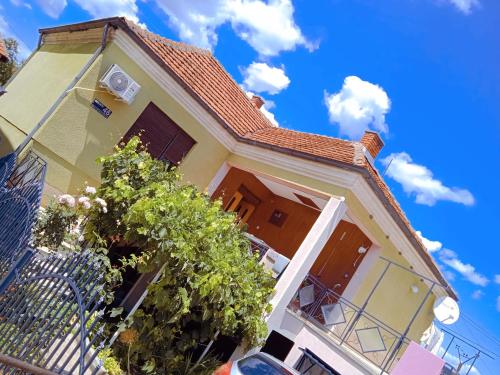 a yellow house with a roof at APARTMAN MINnA in Kuršumlija