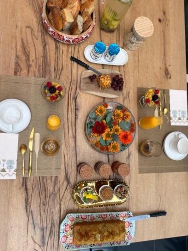a wooden table with plates of food on it at Chez Céline in Cherbourg en Cotentin