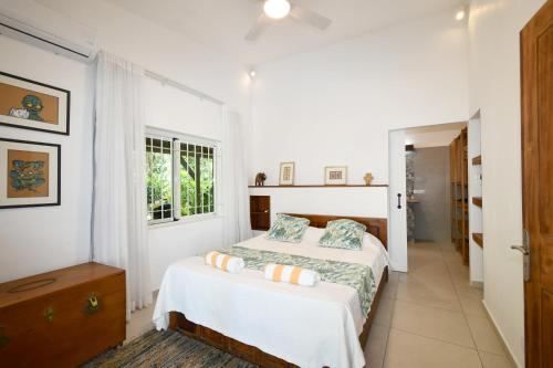 a white bedroom with a bed and a window at Villa Philibert in Riambel