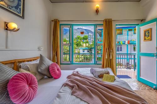a bedroom with a bed with pink pillows and a window at The Hood Bir Billing in Bīr