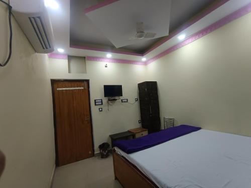 a bedroom with a bed and a wooden door at Hotel Jagdamba Residency in Chupra