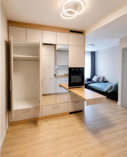 a room with white cabinets and a bed in a room at Kaszmirowy Apartament in Wałcz
