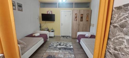 ein kleines Zimmer mit zwei Betten und einem Fernseher in der Unterkunft Azalea in Prilep