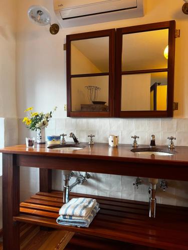a bathroom with two sinks and a mirror at Quinta das Flores in Capelas