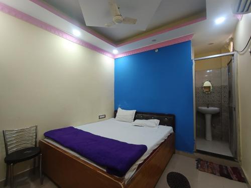 a bedroom with a blue wall and a bed and a sink at Hotel Jagdamba Residency in Chupra