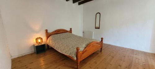 a bedroom with a bed and a lamp on a wooden floor at Ecrin de Verdure in Anneyron