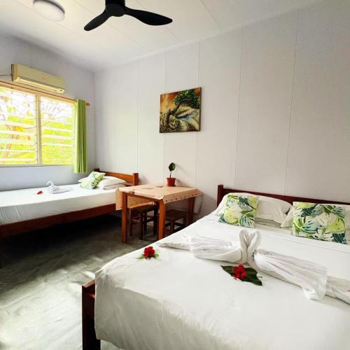 a bedroom with two beds and a table and a window at Room With A View & Apartment Style in Port Vila