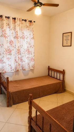 a bedroom with two beds and a ceiling fan at Unamar Beach in Cabo Frio